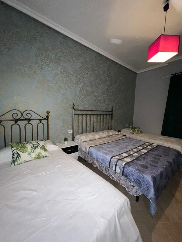 A bedroom with two single beds, a nightstand, a small table with a plant, and a hanging red light fixture. - CT 355 AL - Faro's Pechina Rural (Pechina)