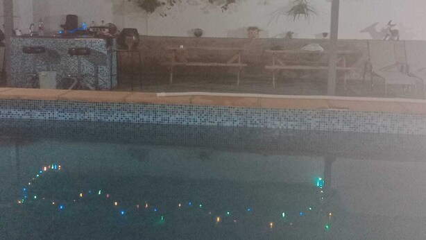 A poolside area with a tiled edge, outdoor seating, and string lights. - CT 355 AL - Faro's Pechina Rural (Pechina)