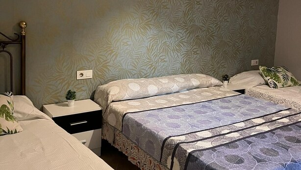A bedroom with two beds, a nightstand, and a wall with a leaf pattern. - CT 355 AL - Faro's Pechina Rural (Pechina)