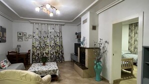 A living room with a sofa, a dining table, and a TV. There is a staircase leading to another room. - CT 355 AL - Faro's Pechina Rural (Pechina)