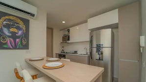 A modern kitchen with a central island, stainless steel appliances, and a microwave above the counter.