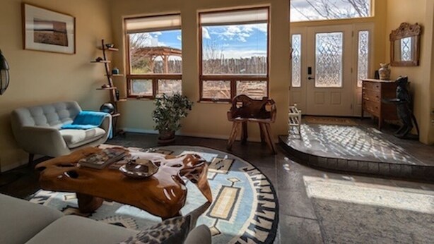 Un salon chaleureux avec une cheminée, un canapé, une table basse et une vue dégagée grâce à de grandes fenêtres.