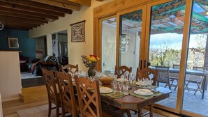Un coin repas avec une table en bois dressée pour six personnes, entourée de chaises en bois.
