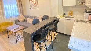 A modern apartment with a dining area, kitchen, and living room. - Taksim Casavilla Hotel (Istanbul)