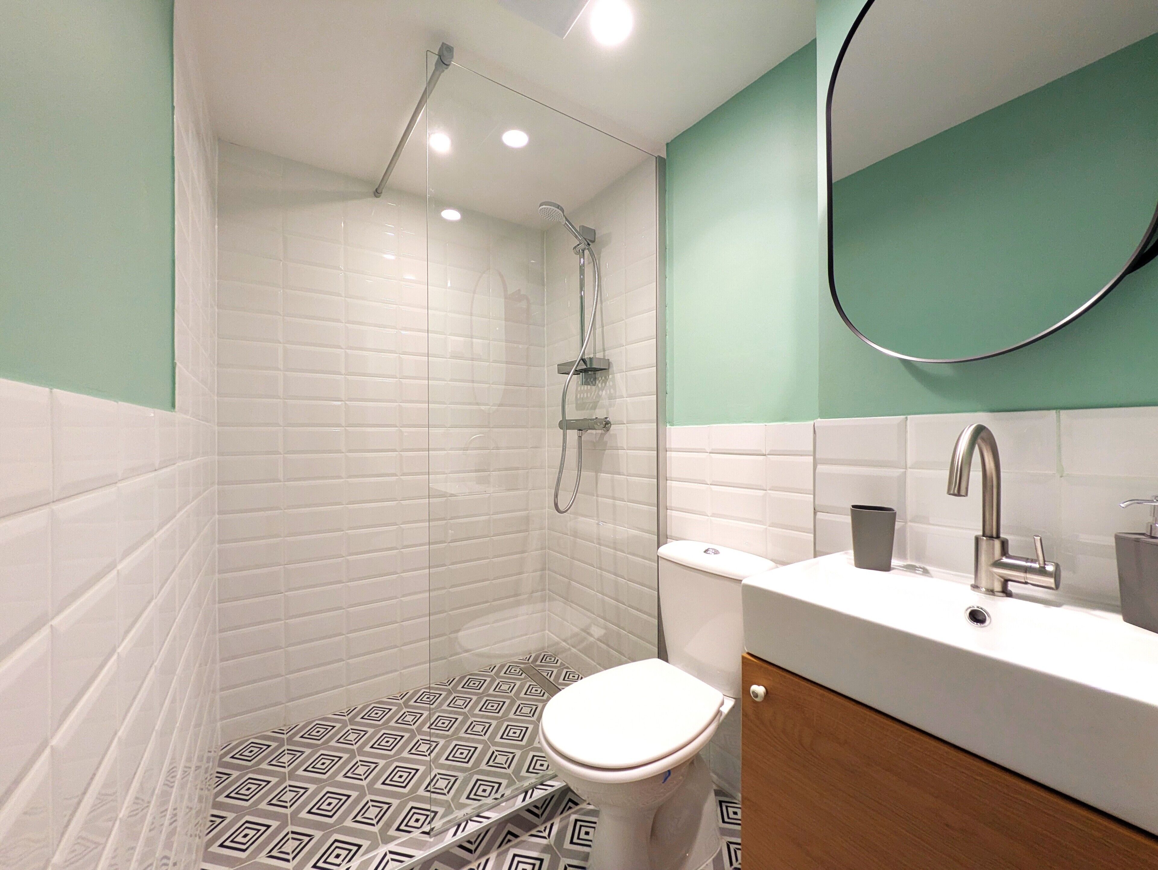 Un baño moderno con ducha, inodoro y lavabo.