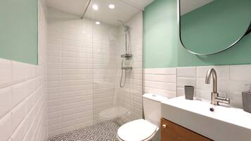 Un baño moderno con ducha, inodoro y lavabo.