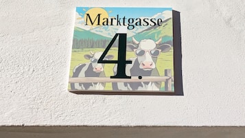 A house number sign with a cow illustration and the text "Marktgasse 4".