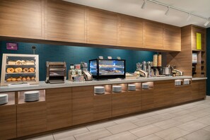 A modern breakfast bar with a variety of food options, including pastries and cereals.