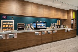 Um balcão de café da manhã moderno com diversas opções de alimentos, incluindo pães e cereais.