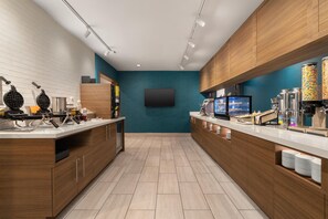 Una cocina moderna con máquinas para hacer gofres, un televisor de pantalla plana y una estación de café.