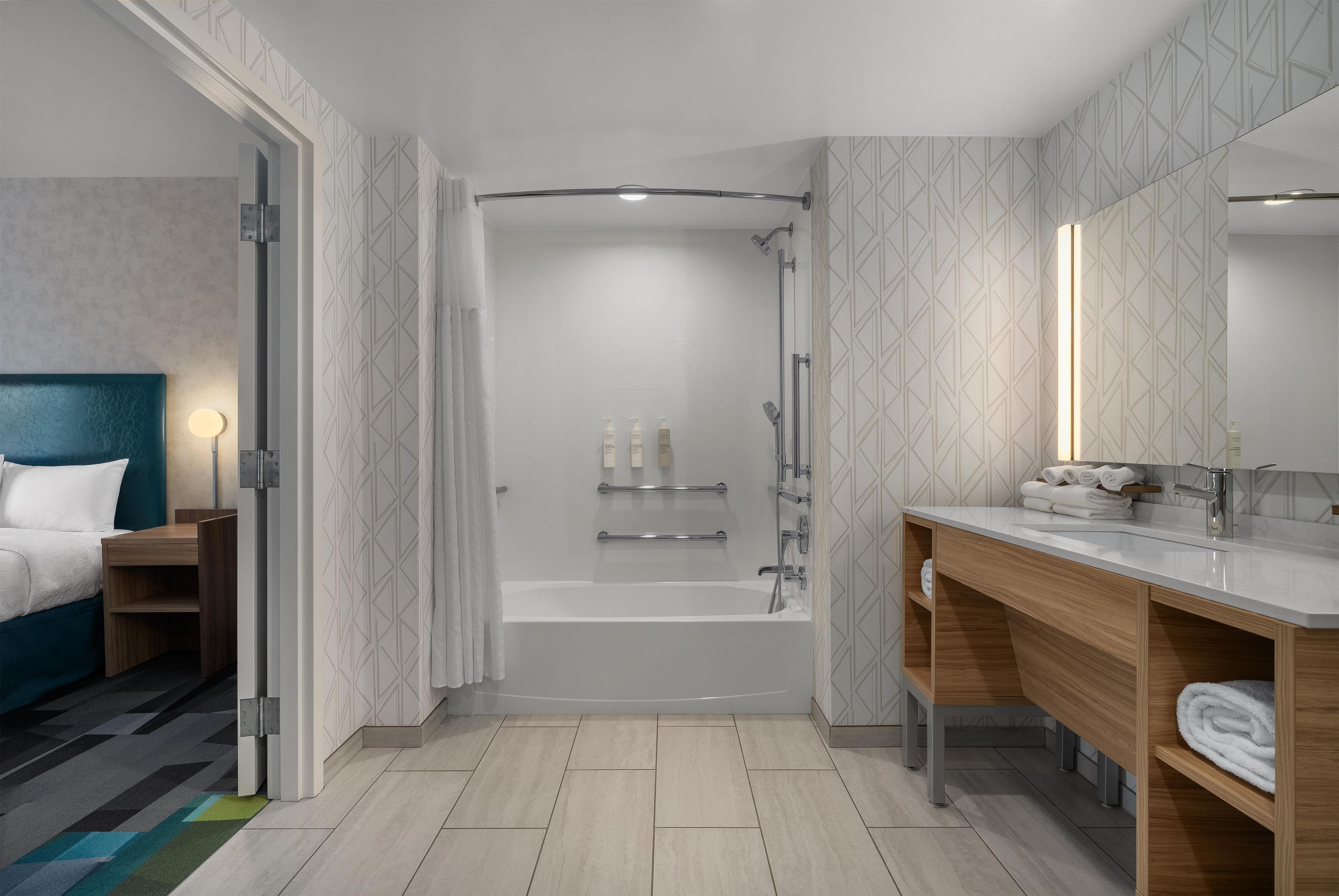 Ein modernes Badezimmer mit Dusche, Badewanne und Waschtisch mit Spiegel.