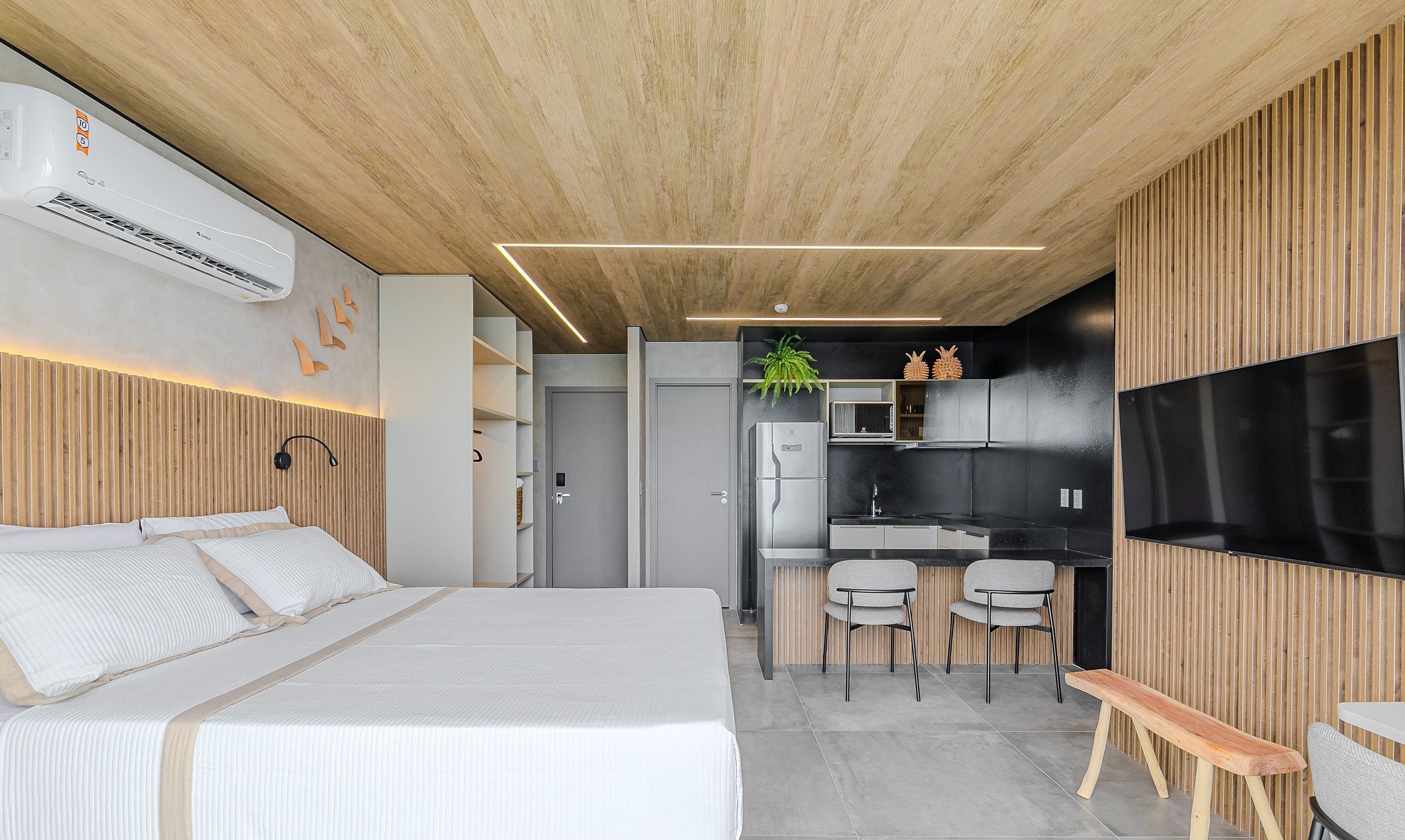 Un dormitorio moderno con cama, mesitas de noche y un equipo de aire acondicionado.