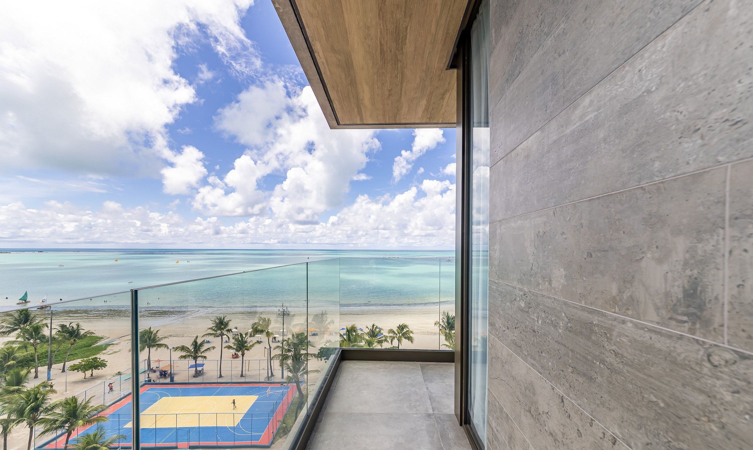 A balcony with a view of a beach and ocean.
