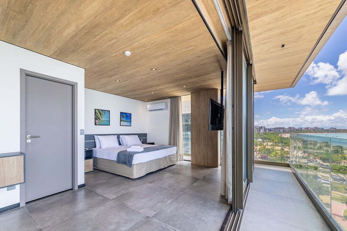 Une chambre d’hôtel moderne dotée d’un grand lit, d’une télévision et d’un balcon offrant une vue sur la ville.