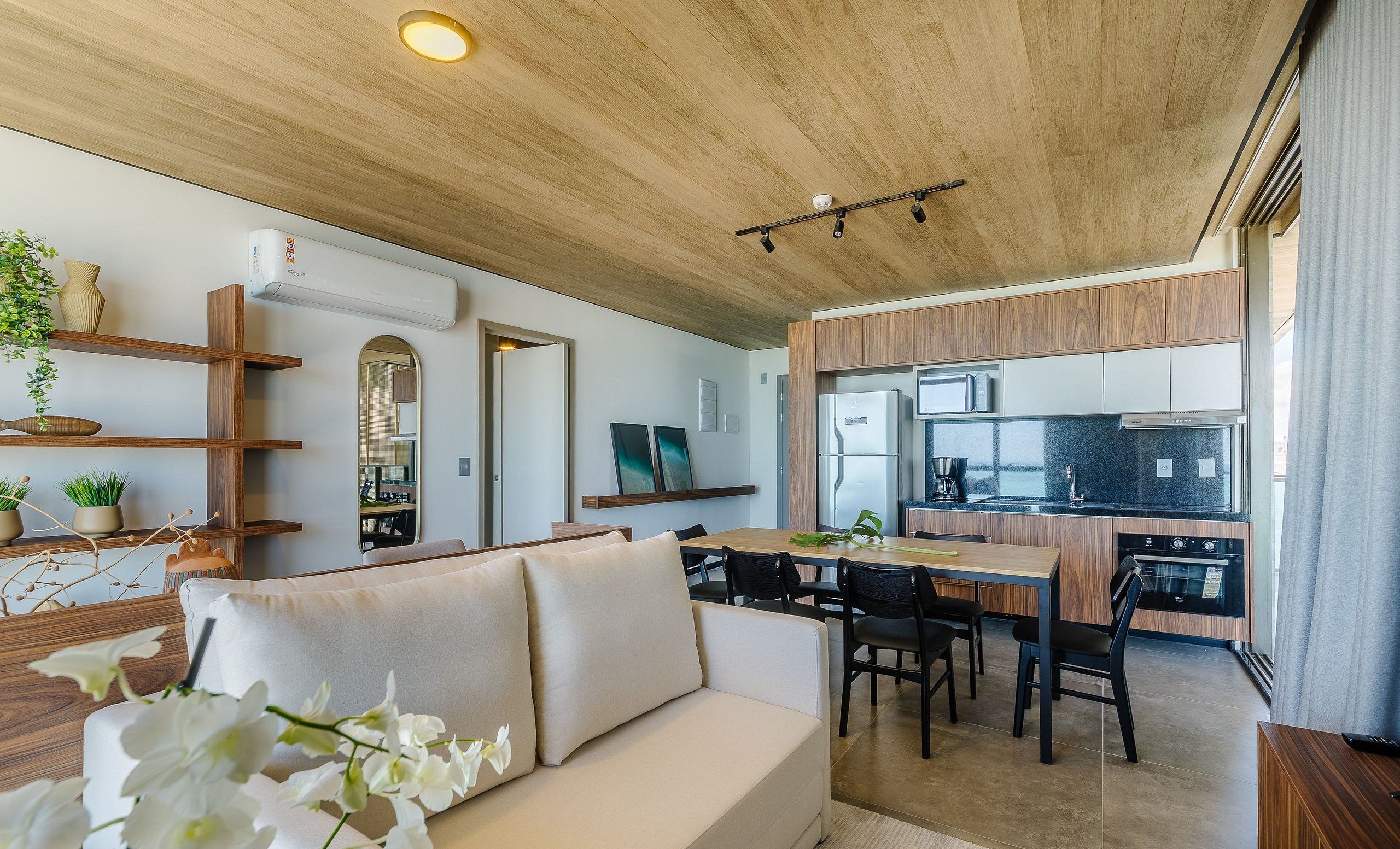 Una cocina moderna con armarios de madera, microondas y refrigerador de acero inoxidable.