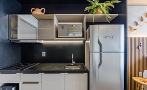 Een moderne keuken met een roestvrijstalen koelkast, een ingebouwde oven en een zwart aanrecht.
