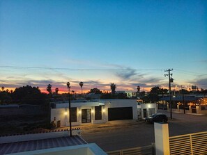 A residential area with modern houses, a paved road, and a clear sky at dusk. - Beautiful house with private pool, only 5 minutes from the sea, comfortable and safe. (Puerto Peñasco)