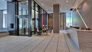A modern reception area with a glass partition, seating, and a reception desk.