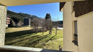 A view from a window overlooking a grassy area with trees and buildings in the background. - 1st floor, balcony, tv, 32m², Villard de Lans (Corrençon-en-Vercors)