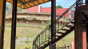 A wooden staircase with a metal railing leading to an upper level.