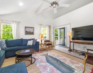 A living room with a sofa, coffee table, and a television. - Charming 3-bedroom cottage with AC and WiFi in Wells: Welcome to the SheShell (wells)