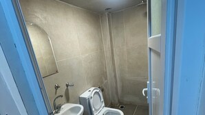 Une petite salle de bain avec des toilettes, un lavabo et une douche.