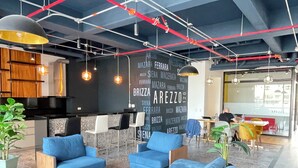 Ein stilvoller Lounge-Bereich mit blauen Sofas, einem Couchtisch und hängenden Pendelleuchten.