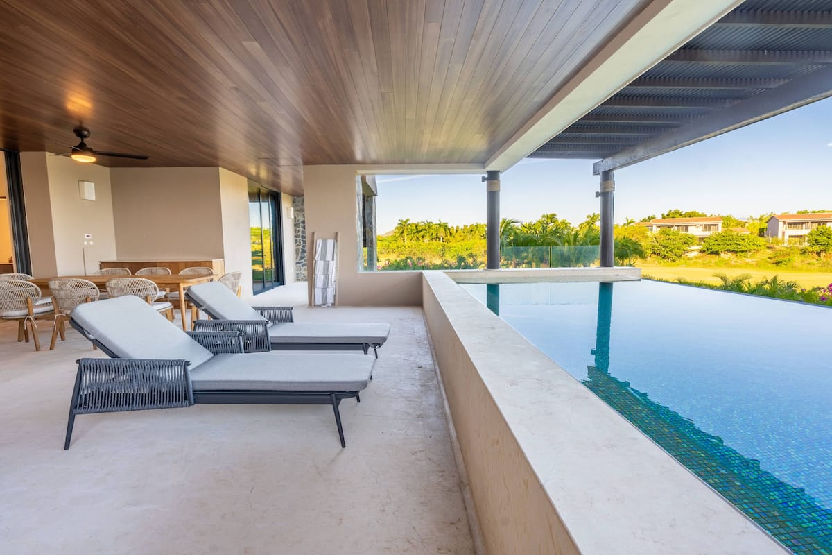 Ein moderner Poolbereich mit Liegestühlen und Blick auf die umliegende Landschaft.