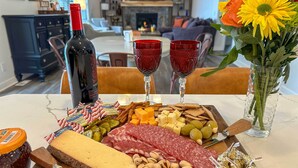 A table with a charcuterie board, wine bottle, and glasses. - Riverfront Retreat/Hot Tub/ Short Walk to Downtown (Bellaire)