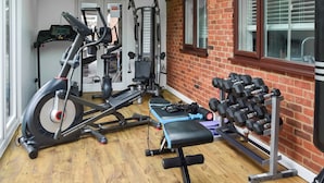 A gym with exercise equipment, a bench, and a dumbbell rack. - A superb holiday choice. (Rackheath, near Wroxham)