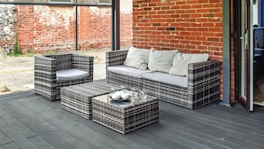 An outdoor patio with wicker furniture and a glass-top table. - A superb holiday choice. (Rackheath, near Wroxham)
