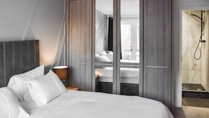 A modern hotel room with a large bed, a bedside table with a lamp, a wardrobe, and a shower area. - A superb holiday choice. (Rackheath, near Wroxham)