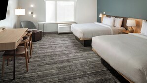 A hotel room with two beds, a desk with chairs, a TV, and a window with blinds. - TownePlace Suites by Marriott West Lafayette (West Lafayette)