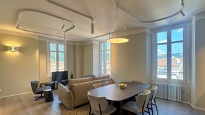 Una sala de estar moderna con una mesa de comedor, sofás y un televisor.