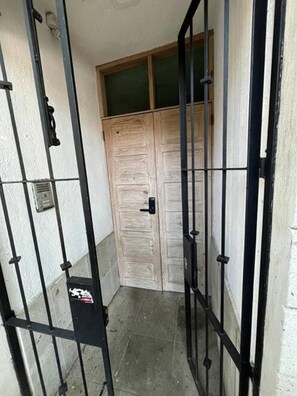 Secure entrance to a residence with a black metal gate and a convenient intercom system.