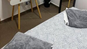 Et soveværelse med et hvidt toiletbord, et rundt spejl og et stort spejl.