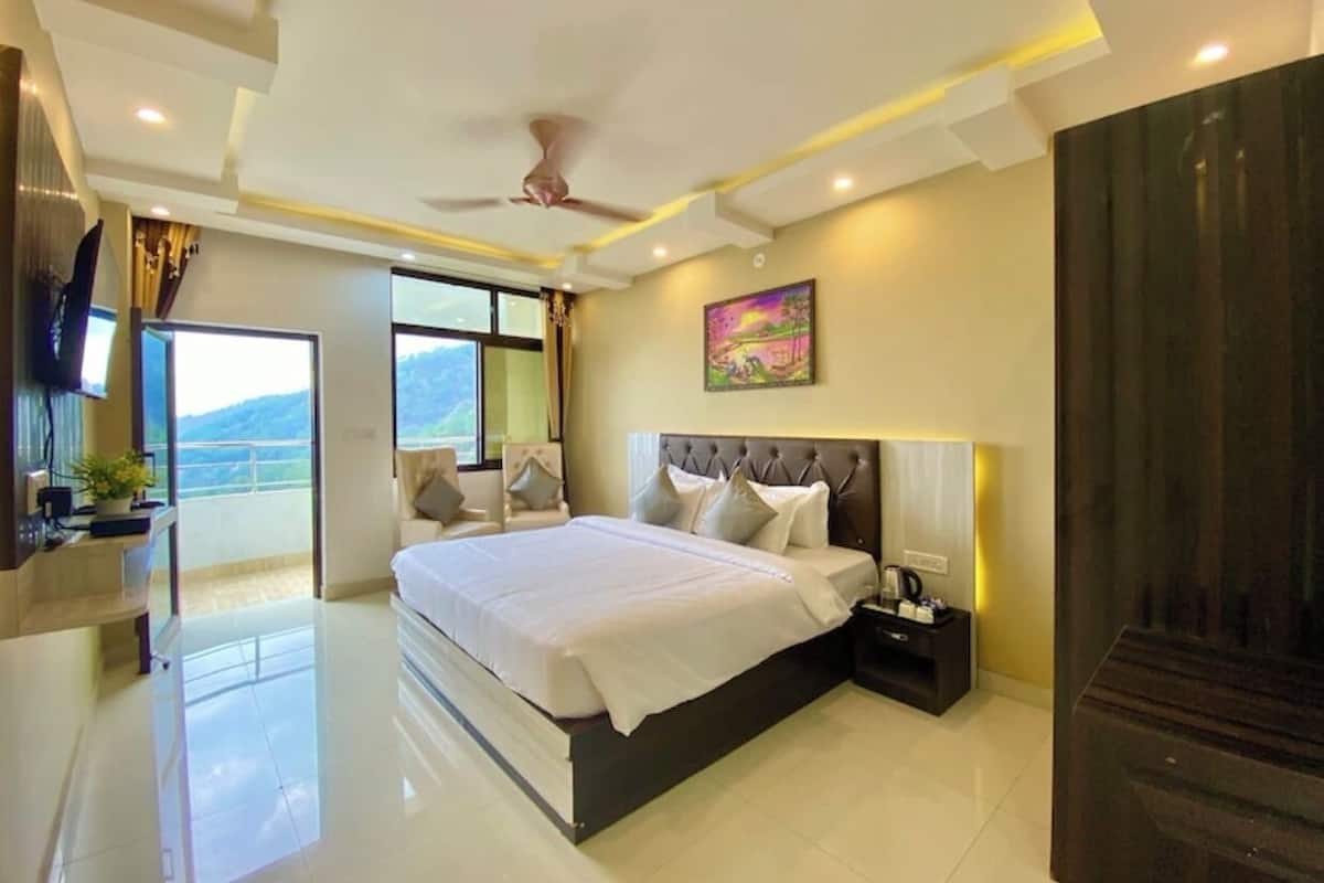 Habitación de hotel moderna con una cama grande, televisión de pantalla plana, escritorio con silla y vistas al exterior.