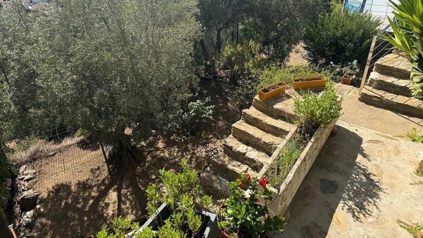 A terrace with stone steps, potted plants, and a view of a coastal town. - Superb sea view apartment with private pool! 5 minutes from the center of Roses. (Roses)