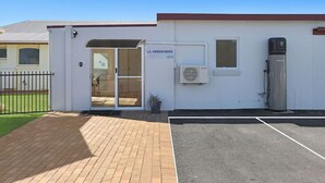 A building with a sign reading "LIL GREENWIVES" and a glass door entrance. - Logans Beach Apartments - Lil Greenviews (Warrnambool)