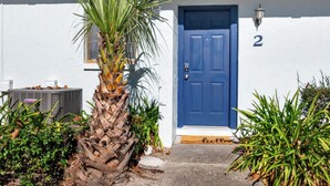 A white building with a blue door, number 2, and a palm tree in the foreground. - Modern & Stylish Condo Near UF - Foxmoor (Gainesville)