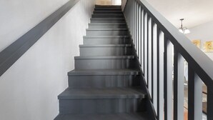 A staircase with a dark gray finish and a simple railing design. - Modern & Stylish Condo Near UF - Foxmoor (Gainesville)