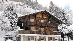 A wooden chalet with a balcony, surrounded by snow-covered trees. - Champéry (CH) winter/summer, confort apart. 4-5p. in wooden chalet, superb view! (Champéry)