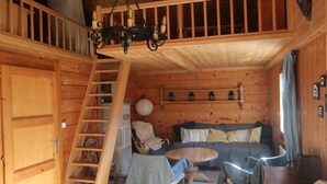 A cozy cabin interior with a wooden staircase, a sofa, a dining table, and a chandelier. - Champéry (CH) winter/summer, confort apart. 4-5p. in wooden chalet, superb view! (Champéry)