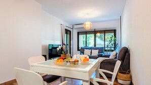 A dining area with a table set for two, a sofa, and a TV in the background. - CT 349 - Stupa Hills - Benalmadena (Benalmádena)