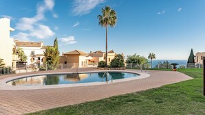 A swimming pool with a palm tree, surrounded by a paved area and a view of the sea. - CT 349 - Stupa Hills - Benalmadena (Benalmádena)