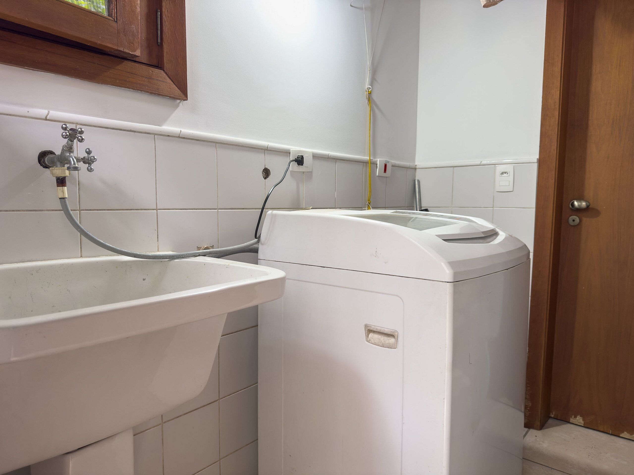 A laundry area with a washing machine and a sink.