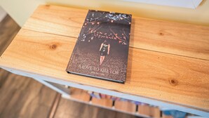 Un livre intitulé « Un amour qui vaut la peine d’être défendu » de Jen McGee, posé sur une table en bois.