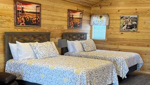 A cozy room with two beds, wooden walls, and ceiling.