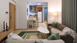 A living room with a sofa, a coffee table, and a dining area with a table and chairs. - Fili's Central Spots (Volos)