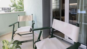 A balcony with two green chairs and a potted plant. - Fili's Central Spots (Volos)